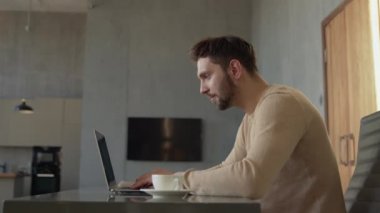 Young male professional typing on laptop in home office