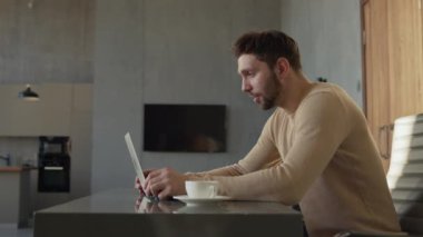 Young man calling with webcam at the desk at home office. Man doing video chat at home