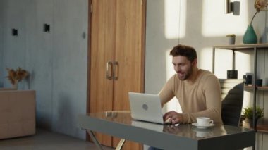 Ofiste görüntülü konferansta gülümseyen iş adamı konuşuyor. Laptop bilgisayarında video görüşmesi yapan yakışıklı bir işçi.