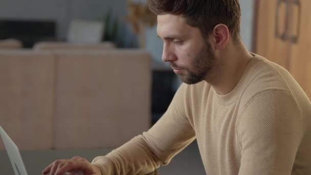 Serious man typing looking for ideas at his desk at home. Emotional man with laptop at work — Stock Video