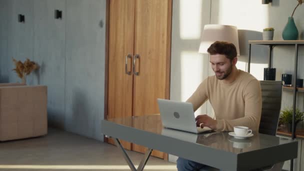 Glimlachende man typt op laptop aan zijn bureau op kantoor. Emotionele man met laptop op kantoor — Stockvideo