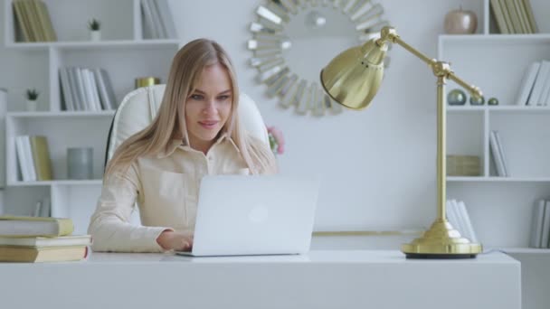 Happy woman receiving good news at the desk in home office — Stock video