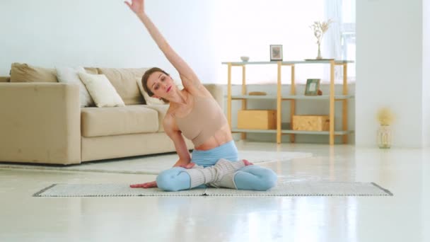 Ein junges Mädchen macht statische Übungen auf einer Yogamatte. Gesunde junge Frau macht Yoga-Übungen — Stockvideo