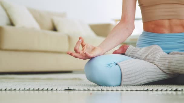 Menina esportiva atraente sentado em posição de lótus de perto. Menina fazendo ioga em casa — Vídeo de Stock