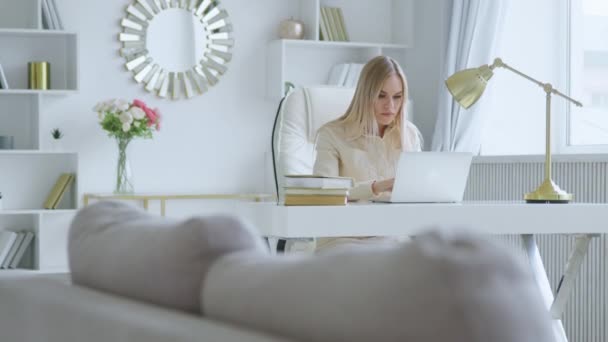 매력적 인 사업가가 가정 사무실에서 노트북으로 타이핑을 하고 있습니다. 직장에서 랩탑을 들고 있는 젊은 생각하는 소녀 — 비디오