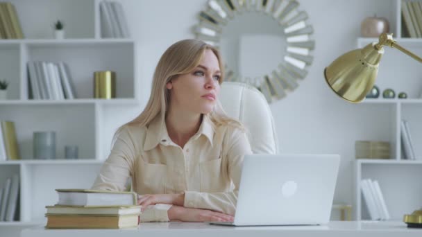 Přemýšlející žena s laptopem u stolu v kanceláři. Mladá krásná dívka s notebookem — Stock video