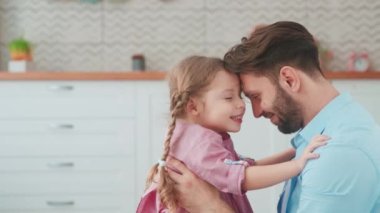 Genç baba evde küçük kızına sarılıyor. Şefkat