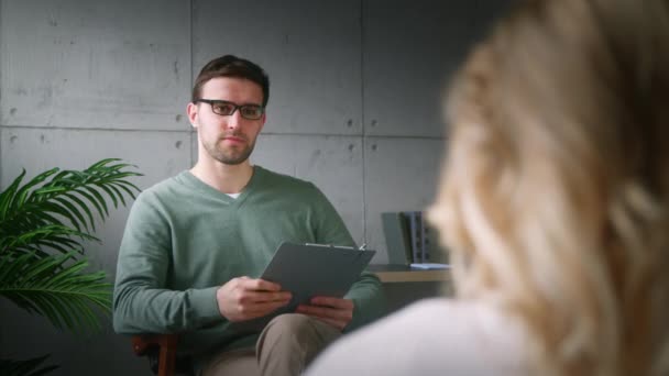 Professionell terapeut pratar med en patient på en soffa inomhus — Stockvideo