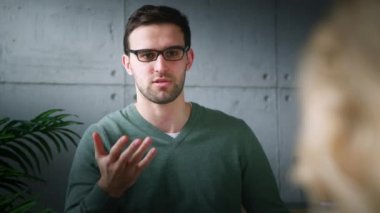 Genç profesyonel terapi seansında hastayla sohbet ediyor.