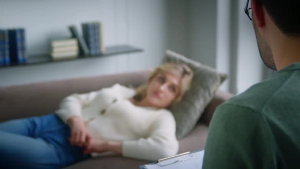 Jovem paciente no sofá falando sobre seu problema com o psiquiatra — Vídeo de Stock