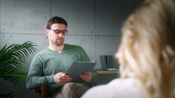 Mladý profesionální psychoterapeut vede rozhovor s pacientem v kanceláři.. — Stock video