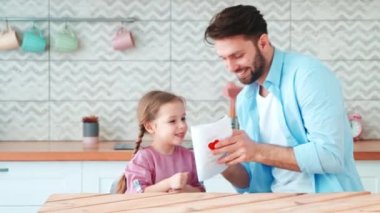 Küçük anaokulu kızı babasına kart veriyor. Babalar günün kutlu olsun.