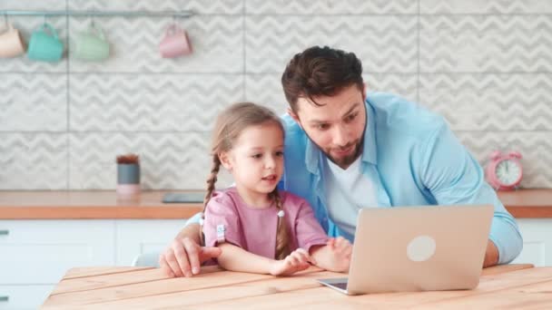 Молодий тато і маленька дочка розмовляють на онлайн-конференції з мамою за допомогою ноутбука. Молода сім'я з дитиною розмовляє — стокове відео