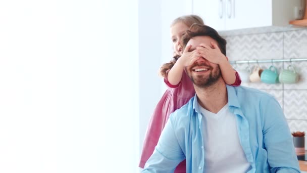 Pappa och dotter umgås. En liten förskola flicka täcker sina pappor ögon med händerna — Stockvideo