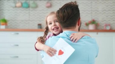 Oturma odasında tatil için babama kart veren tatlı bir kız. Senin için en iyi hediye.