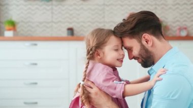 Genç baba evde küçük kızına sarılıyor. Şefkat