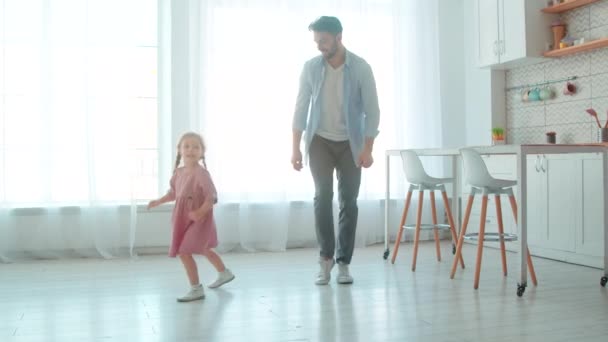 Happy young father and little preschool girl dancing in the living room. Cute princess and her daddy in the room. — Stock Video