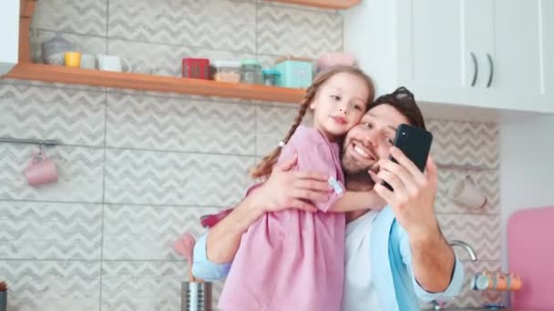 Χαμογελώντας πατέρας και κόρη βγάζοντας selfie στο smartphone. Ο μπαμπάς και η κόρη περνούν χρόνο μαζί.. — Αρχείο Βίντεο