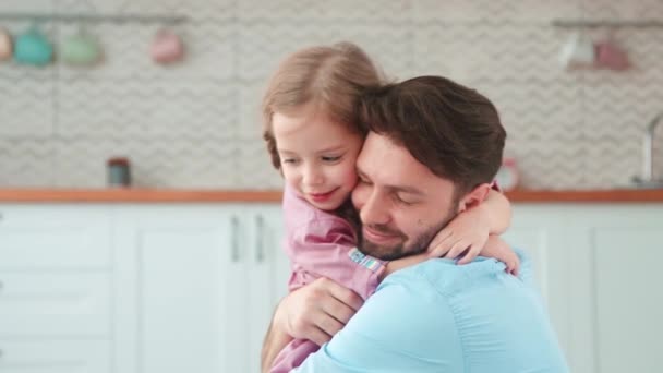 Een tedere omhelzing van vader en dochter. Jonge vader knuffelen kleine dochter — Stockvideo