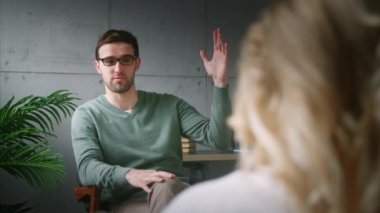 Profesyonel bir psikoterapistin resepsiyonundaki genç hasta. Ofisteki hastaya planı açıklayan psikoterapist.