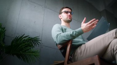 Genç bir profesyonel terapist bir hastaya depresyonun nedenlerini açıklıyor. Terapide panosu olan genç bir adam.