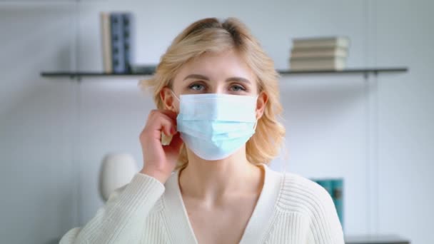 Młoda kobieta zdejmuje maskę medyczną i uśmiecha się patrząc w kamerę. Koncepcja opieki zdrowotnej — Wideo stockowe