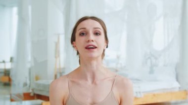 Genç yoga eğitmeni kameraya bakıyor. Atletik kadın video çağrısı yaptı