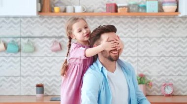 Baba ve kızı birlikte vakit geçiriyorlar. Küçük bir anaokulu kızı elleriyle babasının gözlerini kapatıyor.