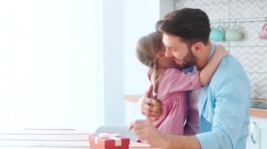 Evde genç bir baba ve küçük bir kızı kucaklamak. Evde mutlu bir aile