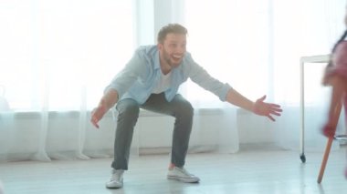 Genç baba, iç mekanda küçük kızına sarılıyor. Babalar Günü