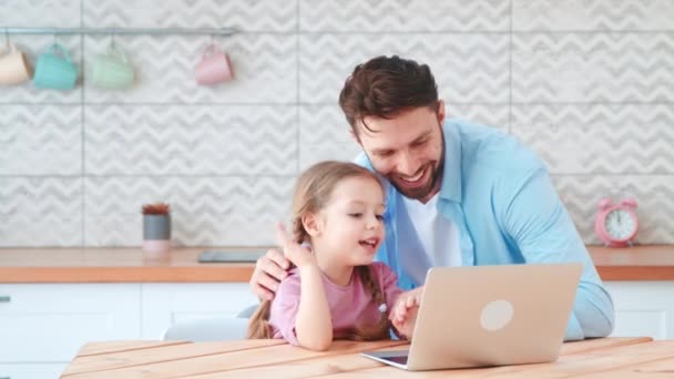 Ung pappa och liten dotter pratar på en online konferens med mamma med hjälp av en bärbar dator. Leende pappa och liten dotter talar på en online-konferens — Stockvideo