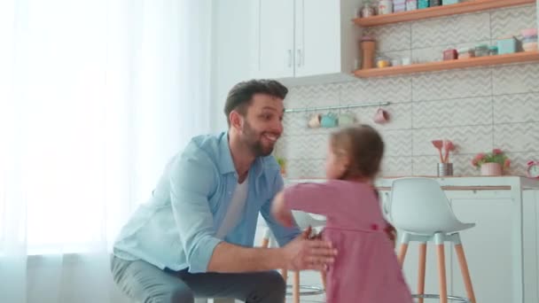 En ung far spyr upp en liten flicka i en heminredning. Fritid lycklig familj — Stockvideo