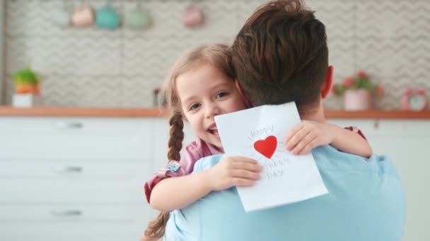 Klein meisje geeft een kaart aan papa voor een vakantie. Het beste cadeau voor jou — Stockvideo