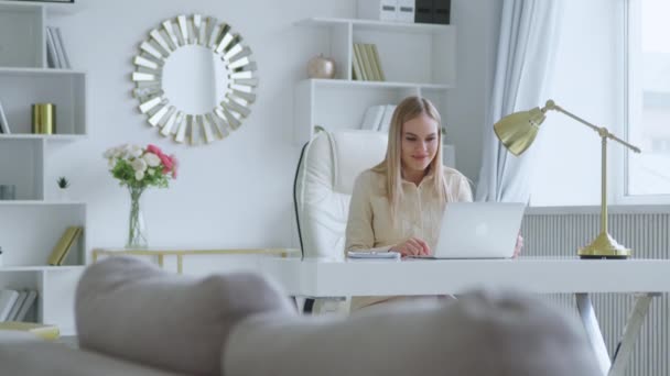 Jovem mulher atraente segurando videoconferência remotamente da sala branca em casa — Vídeo de Stock