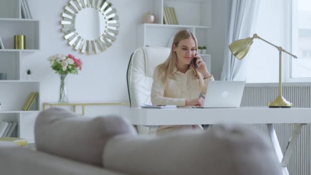 Donna che lavora in una stanza bianca. Giovane donna che parla al telefono a casa — Video Stock