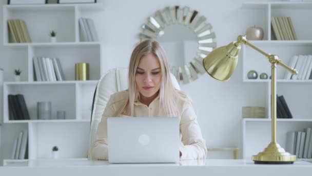 Una joven trabajadora en una habitación blanca. Mujer sonriente comunicándose con sus colegas — Vídeos de Stock