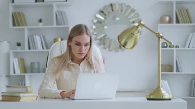 Ofiste dizüstü bilgisayarda yazan ciddi bir kadın. Genç kadın profesyonel masada bilgisayar kullanıyor.