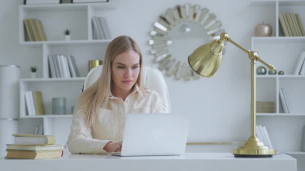 Femme sérieuse tapant sur ordinateur portable au bureau à la maison — Video