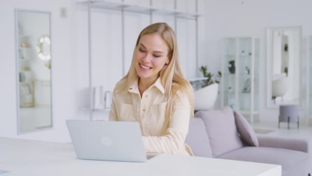 Sorrindo mulher atraente segurando videoconferência remotamente da sala branca — Vídeo de Stock