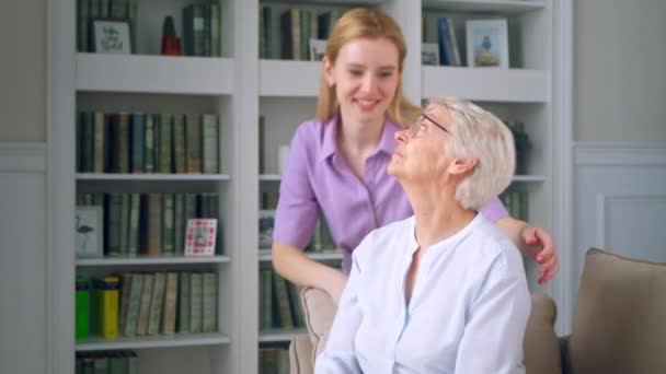 Famille souriante regardant la caméra avec un sourire sur le fond des étagères de la bibliothèque — Video