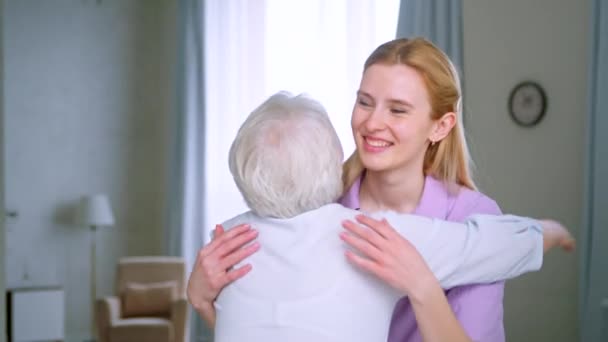 Ältere Mutter und kleine Tochter umarmen sich zu Hause. Glückliche Familie — Stockvideo