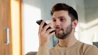 Gülümseyen erkek bir sesli mesaj kaydediyor