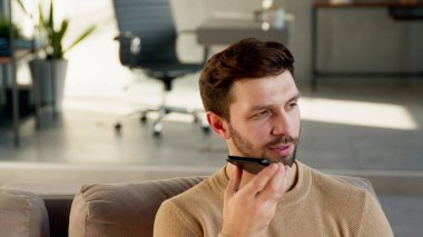 Genç adam telefonda bir sesli mesaj kaydediyor.