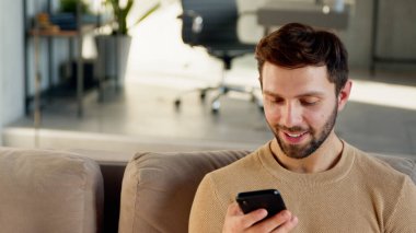 Evde telefon kullanan yakışıklı adam.