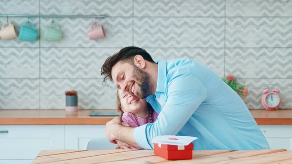 Abraçando o jovem pai e a pequena filha em casa interior — Fotografia de Stock