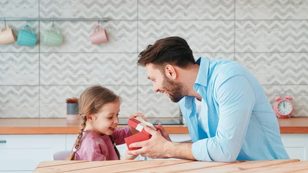 Padre dando un regalo de cumpleaños a su hija — Foto de Stock