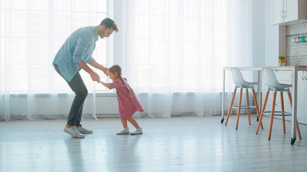 Feliz padre joven y niña preescolar bailando en casa — Foto de Stock