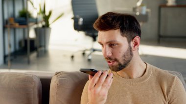 Genç adam bir sesli mesaj kaydediyor.