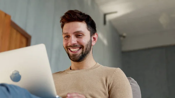 Jonge glimlachende man communiceert via videoconferentie — Stockfoto