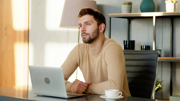 Hombre de pensamiento joven con portátil en el trabajo remoto —  Fotos de Stock